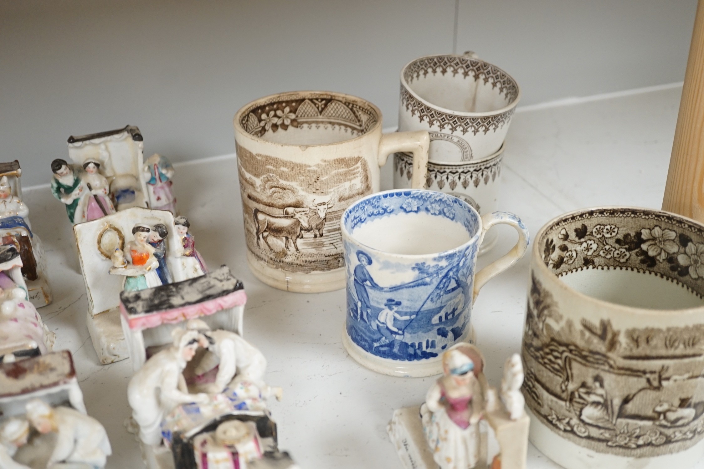 A collection of German porcelain Fairings, including Possneck, and four printed creamware mugs and a cup